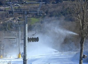 Six pack to go. Seated six across and cruising, some of the Summit Express' first passengers soar above snowmaking.